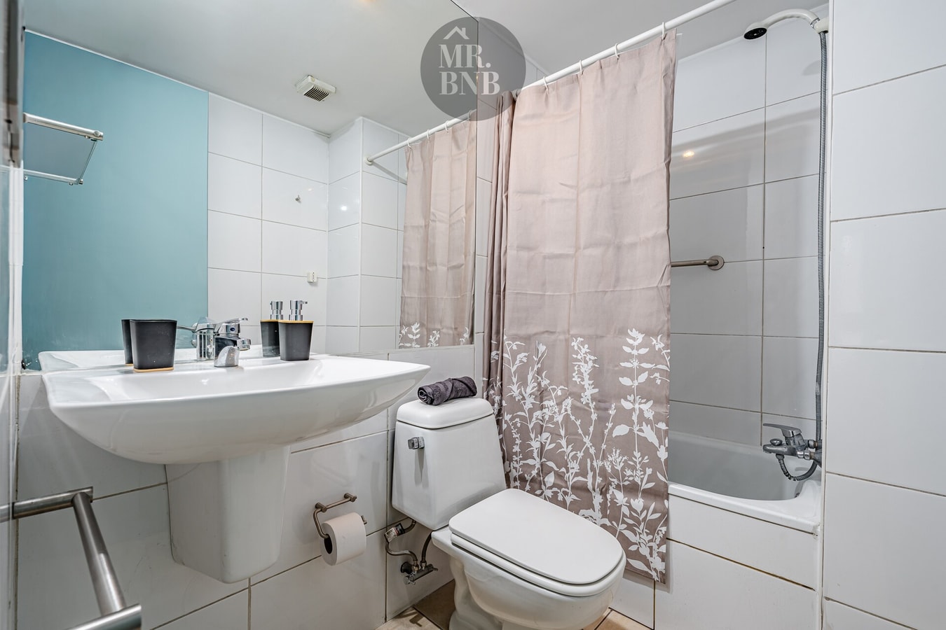 Baño con lavamanos, inodoro, tina con cortina y muro celeste