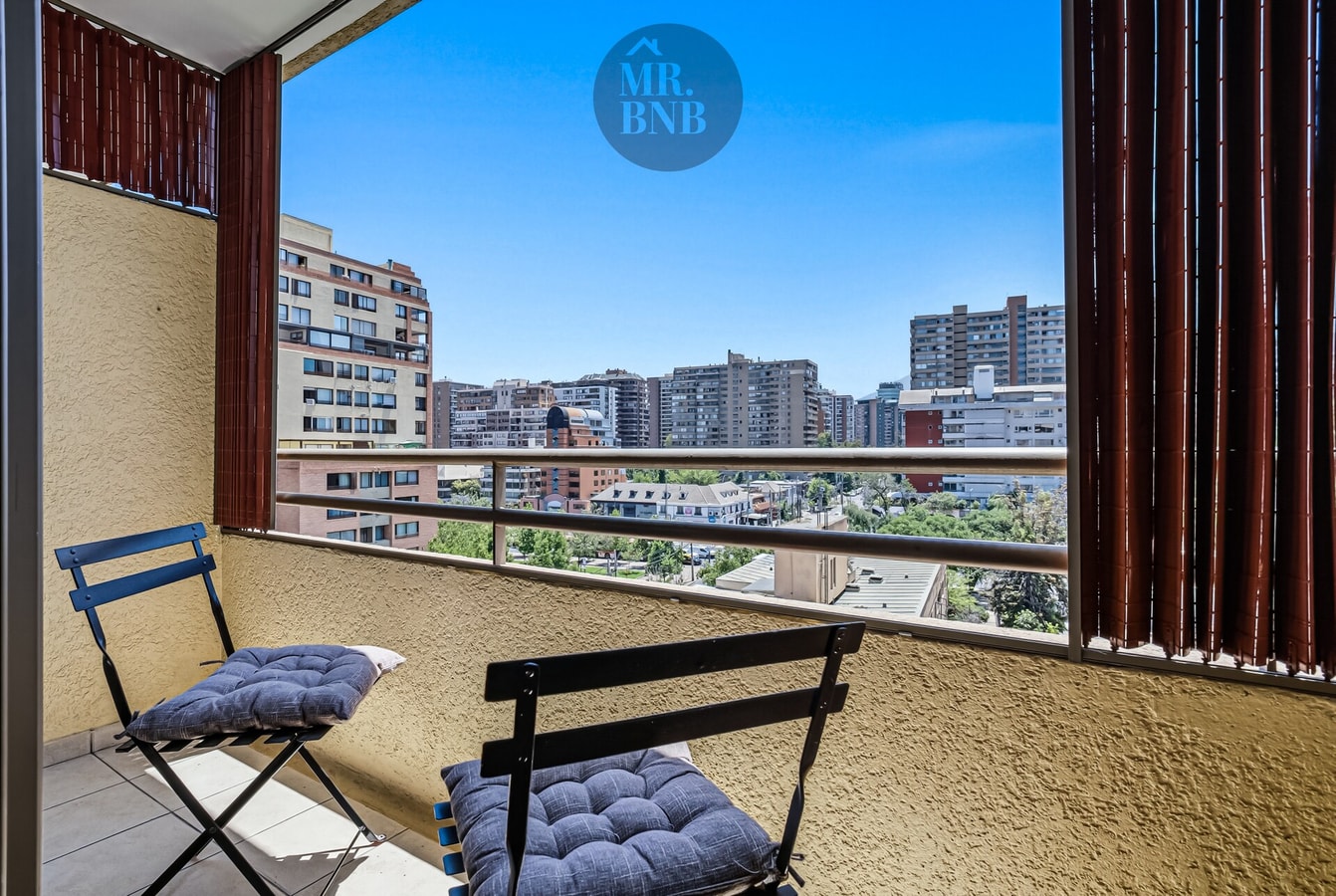 Terraza privada con dos sillas plegables y vista a la ciudad.