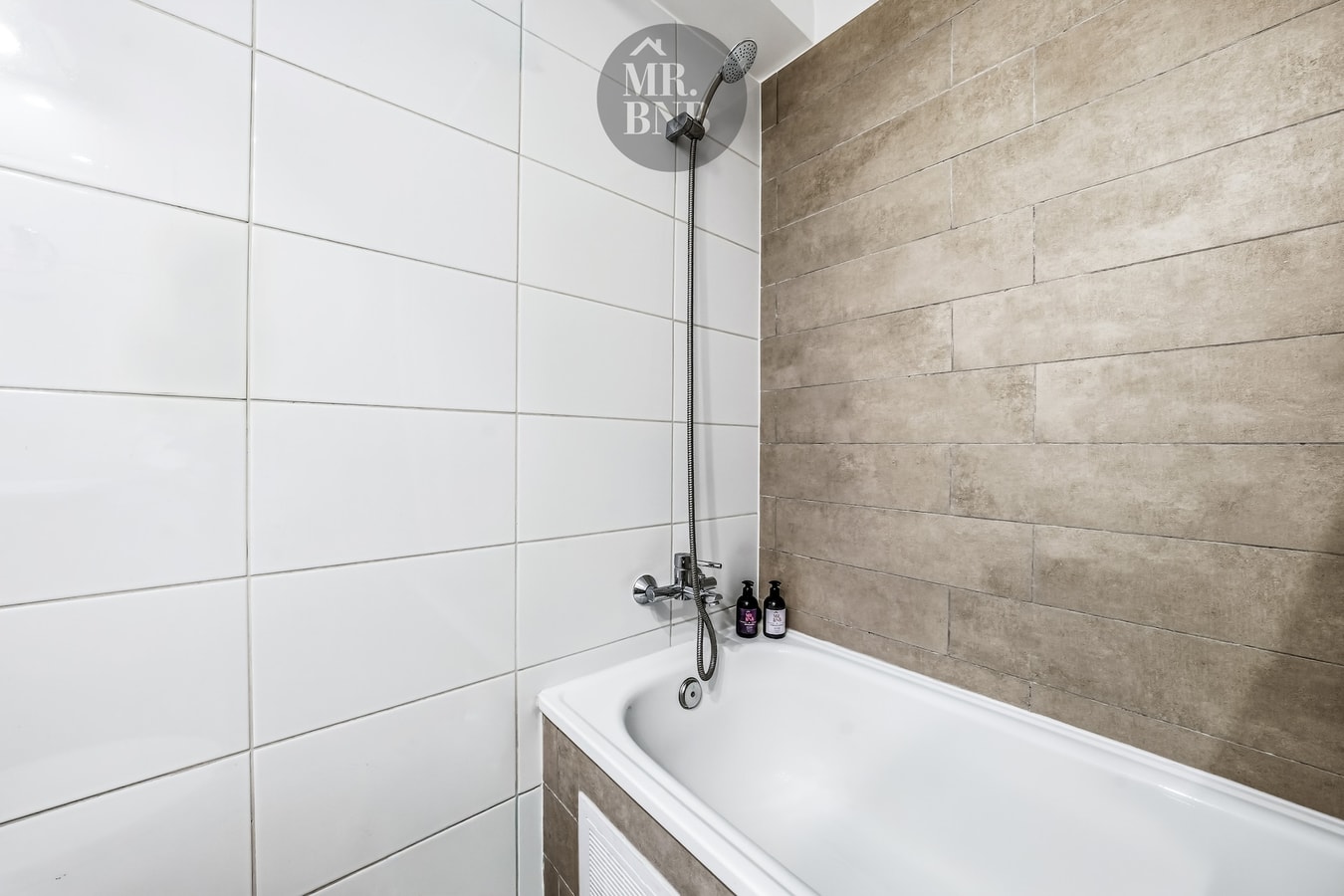 Detalle de tina con revestimiento en madera y azulejos, grifería y amenities