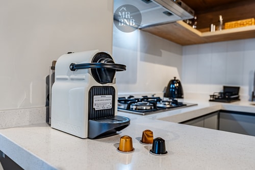 Detalle de cocina con cafetera de cápsulas y cocina a gas