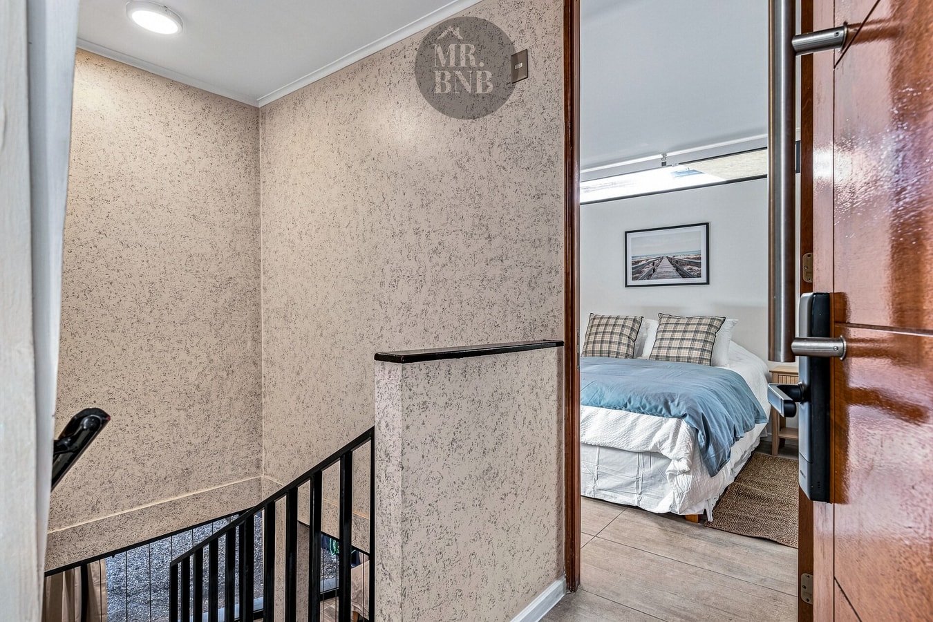 Pasillo y escalera hacia el dormitorio del segundo nivel, con espejo