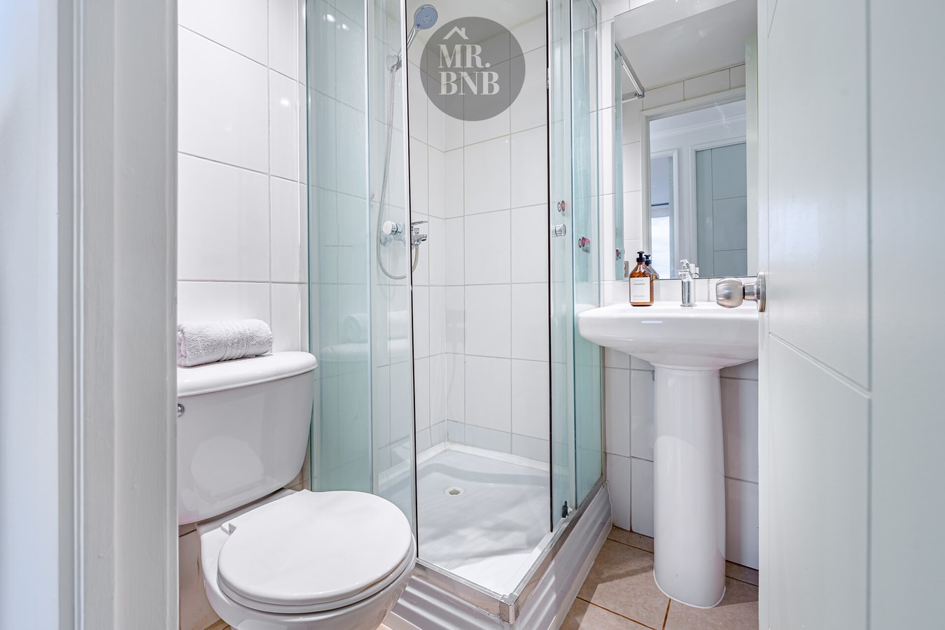 Baño con ducha de vidrio, inodoro y lavamanos