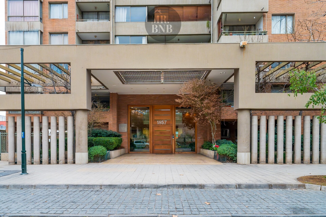 Fachada del edificio con acceso principal y jardineras