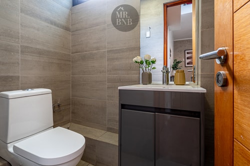 Baño con WC, mueble vanitorio y flores decorativas