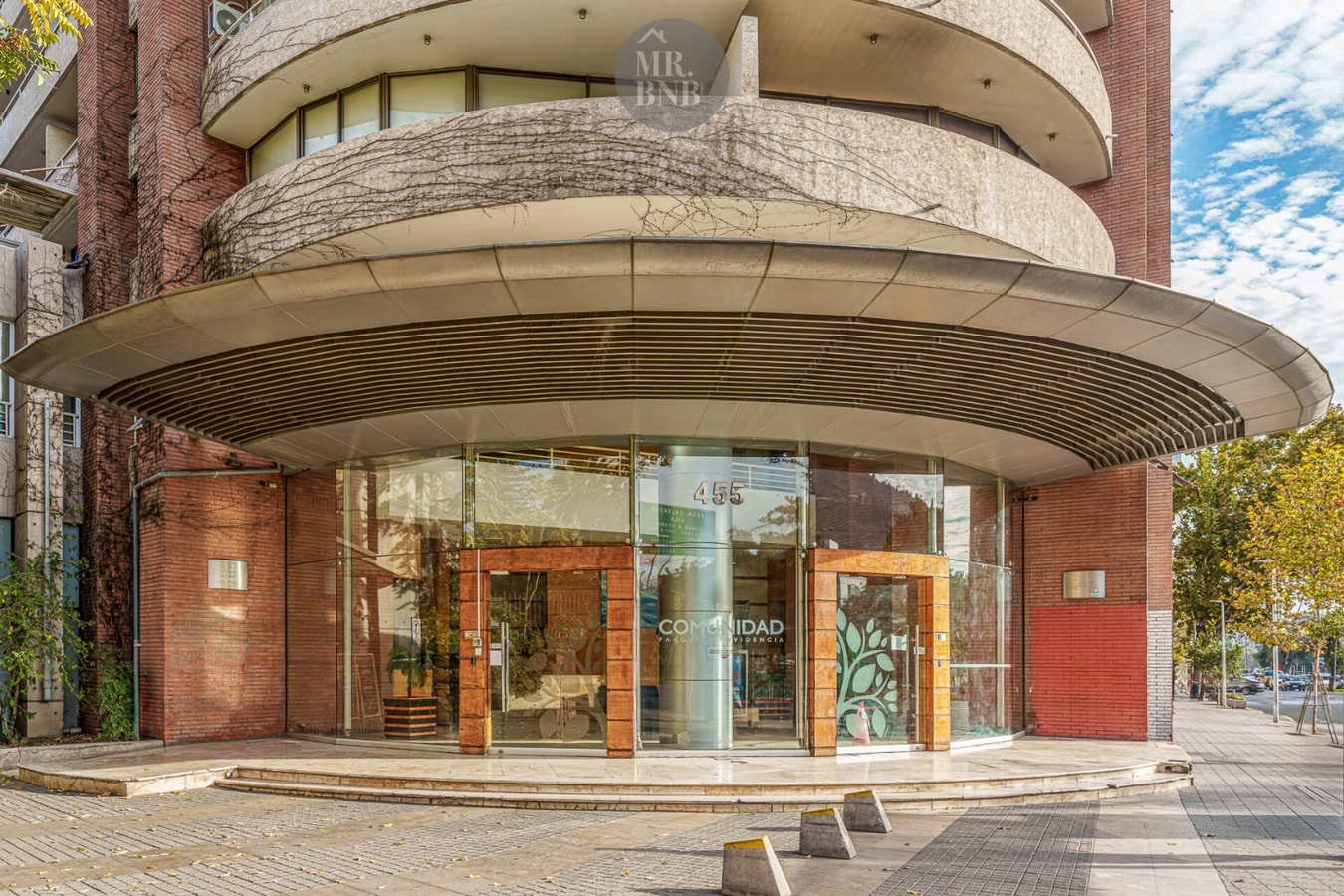 Fachada curva del edificio con acceso vidriado de diseño arquitectónico