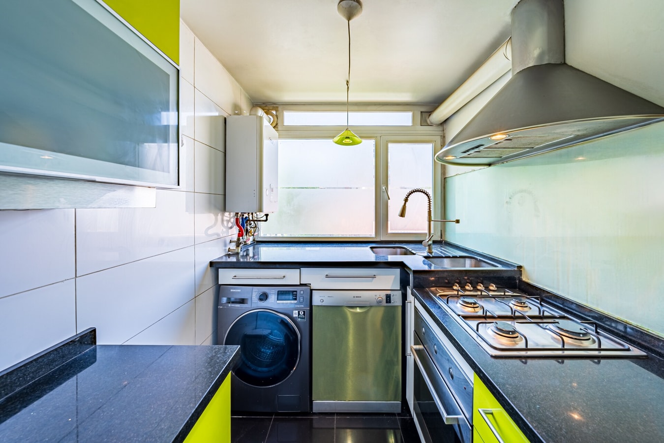 Cocina equipada con lavadora, secadora, cocina a gas, campana extractora y muebles verde lima.