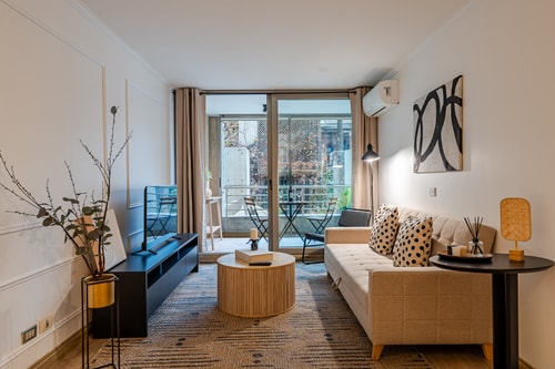 Living con sofá, mesa de centro y ventanal hacia terraza