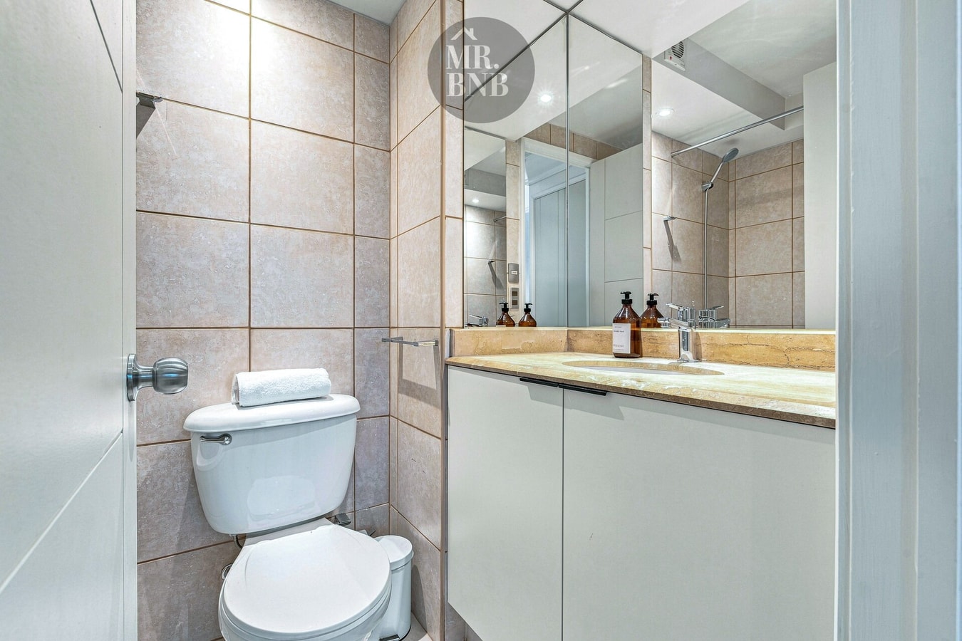 Baño con inodoro, lavamanos y espejo grande