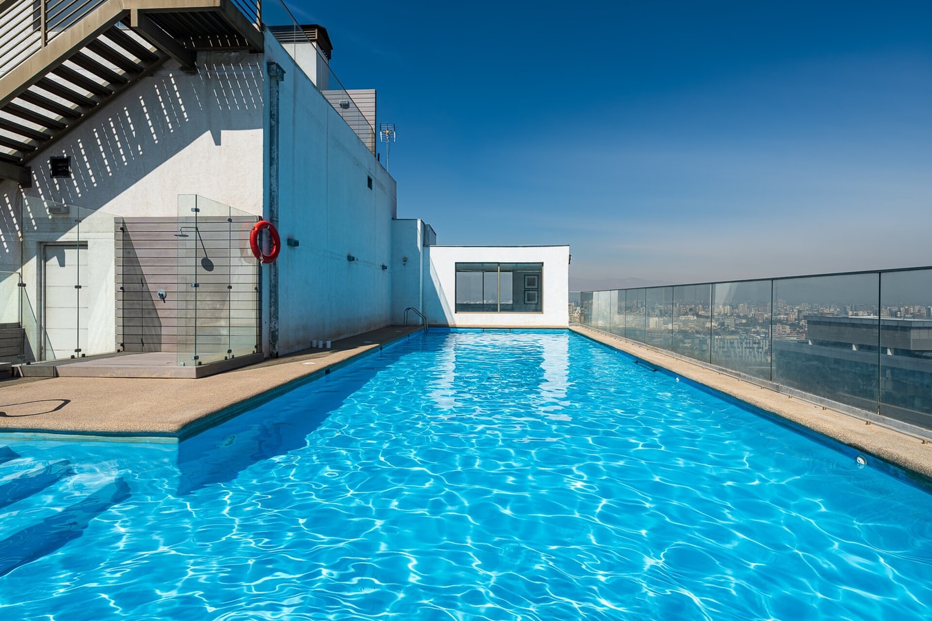 Piscina en azotea con deck y vista despejada a la ciudad