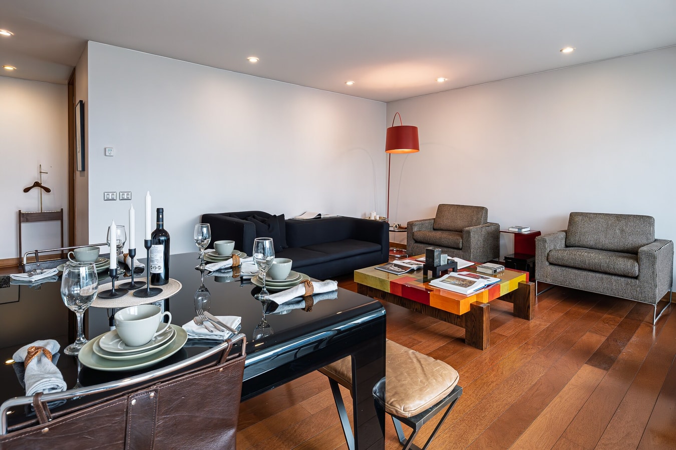 Living comedor con mesa puesta, sofás y lámpara de piso.