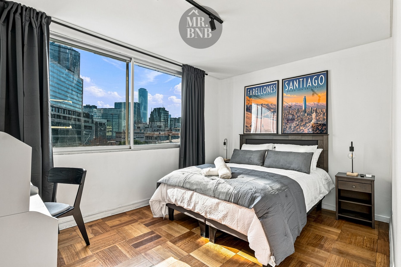 Dormitorio con cama queen, veladores, cuadros de ciudades y ventanal con cortina