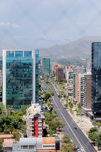 Vista panorámica de la ciudad y la cordillera desde el departamento, con edificios y avenida