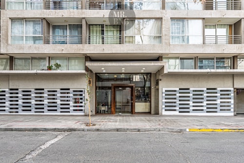 Fachada del edificio con acceso principal y buzones en la entrada.