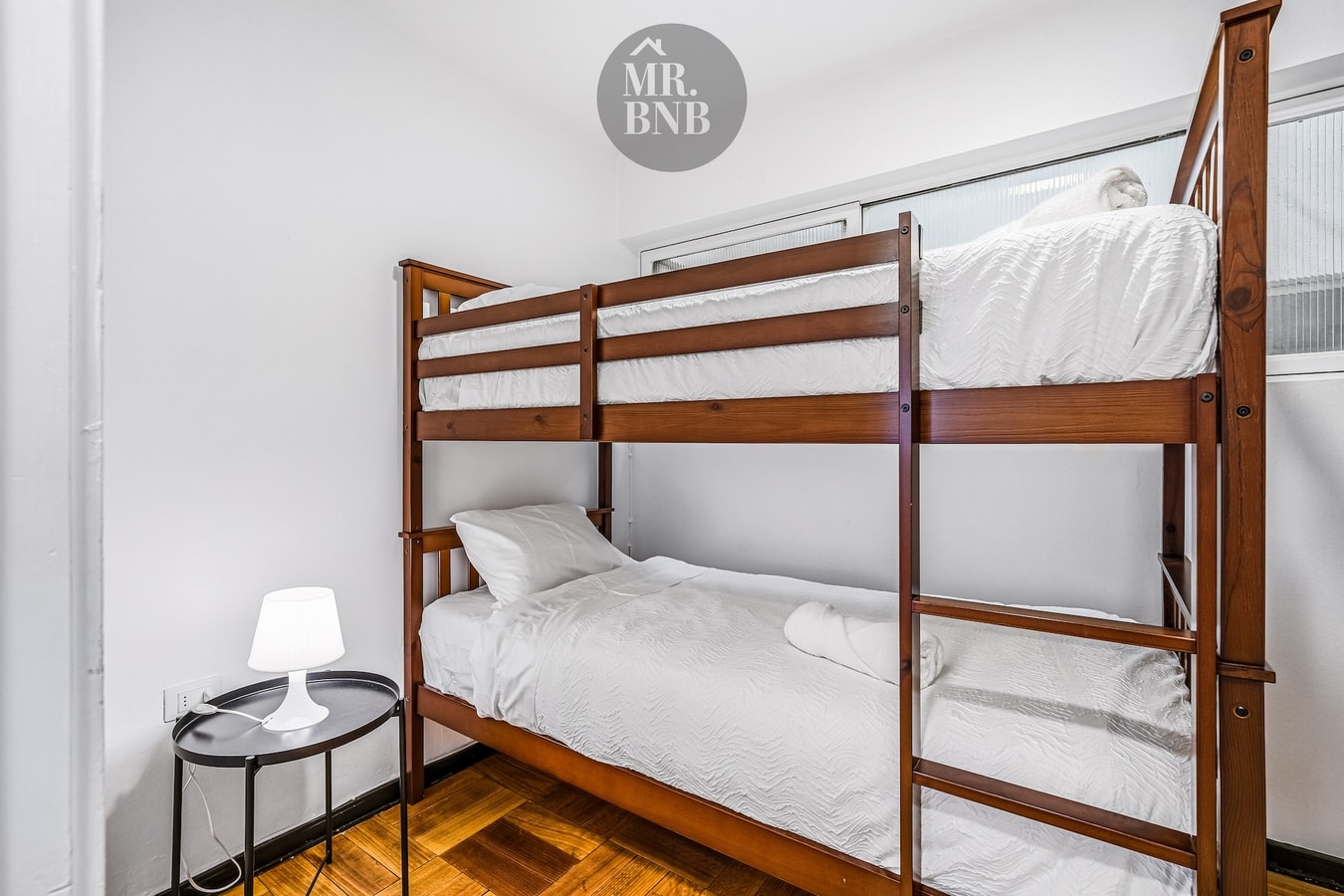 Dormitorio con litera de madera para dos personas y velador