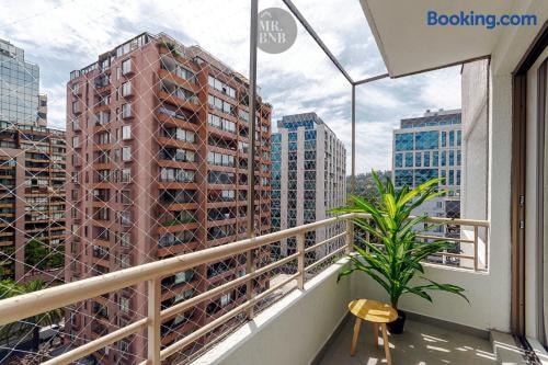 Balcón con baranda y vista a edificios de ladrillo y torres de la ciudad.