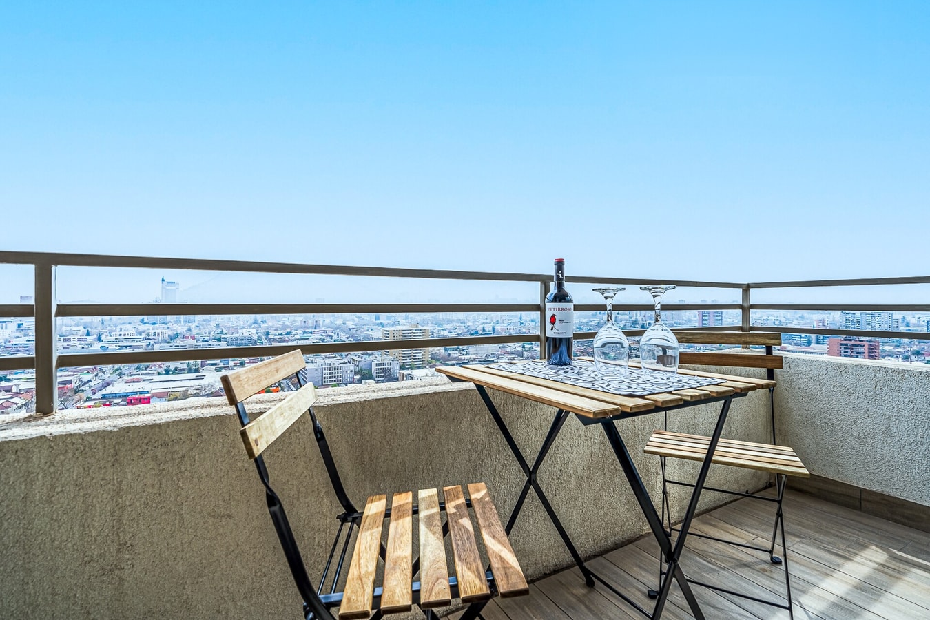 Balcón con mesa, sillas y vista panorámica a la ciudad
