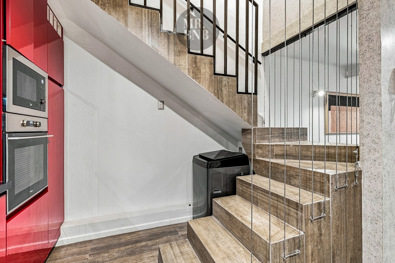 Escalera de madera hacia el segundo nivel junto a muro blanco