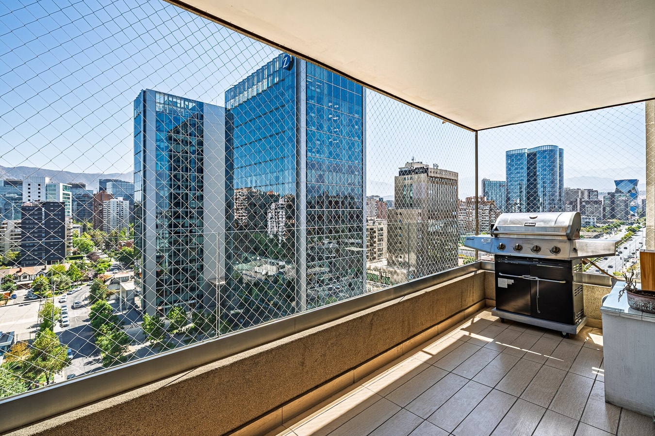 Terraza privada con parrilla y vista a edificios de oficinas