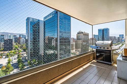 Terraza privada con parrilla y vista a edificios de oficinas
