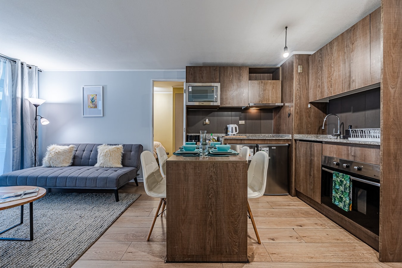 Living comedor con sofá, mesa de centro y cocina al fondo