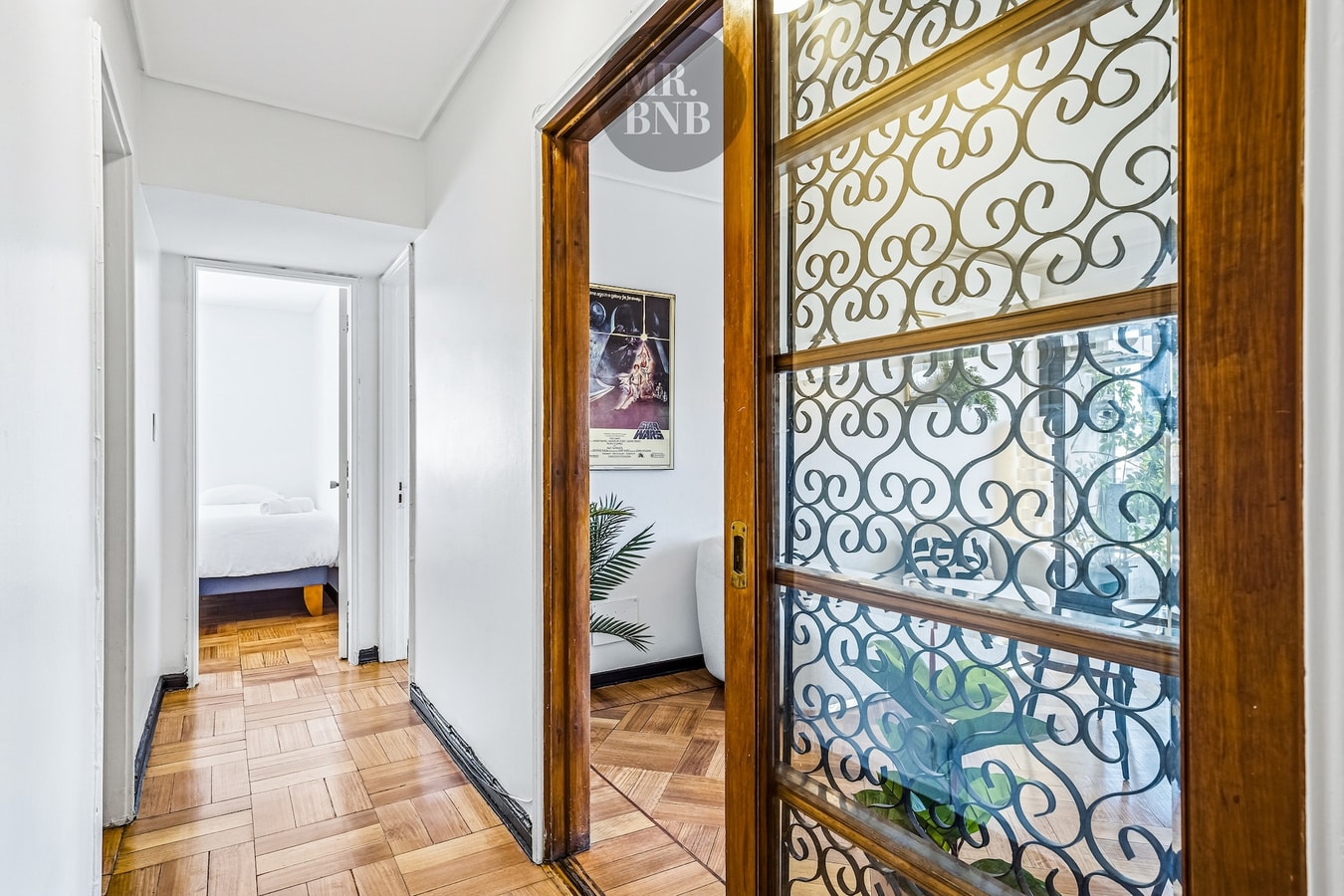 Pasillo interior con puerta de vidrio con rejilla decorativa, acceso a dormitorios