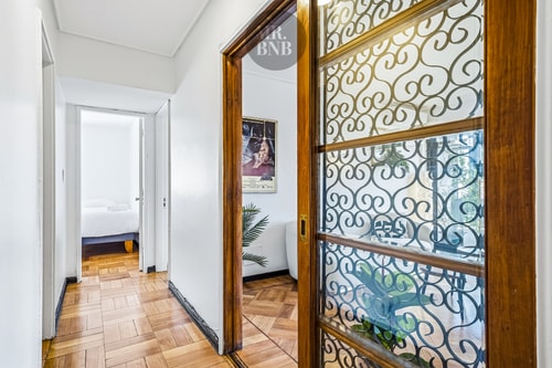 Pasillo interior con puerta de vidrio con rejilla decorativa, acceso a dormitorios