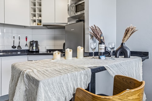 Cocina con isla vestida con mantel, copas de vino y velas decorativas
