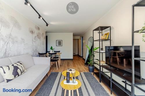 Living con sofá, mesa de comedor con sillas y mueble con televisor al fondo.