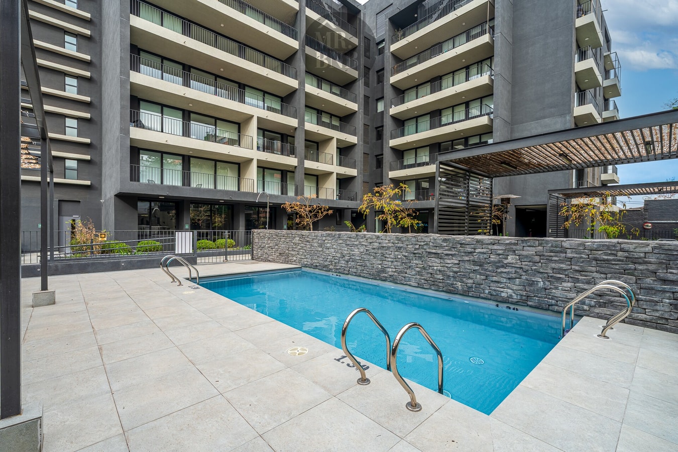 Piscina rectangular exterior rodeada de terraza de piedra
