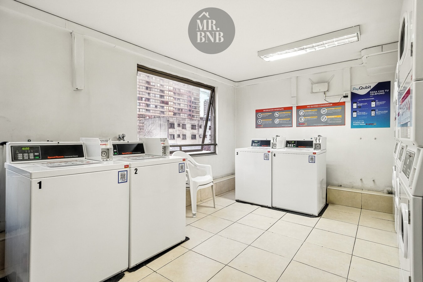 Lavandería del edificio con varias lavadoras y secadoras de uso compartido