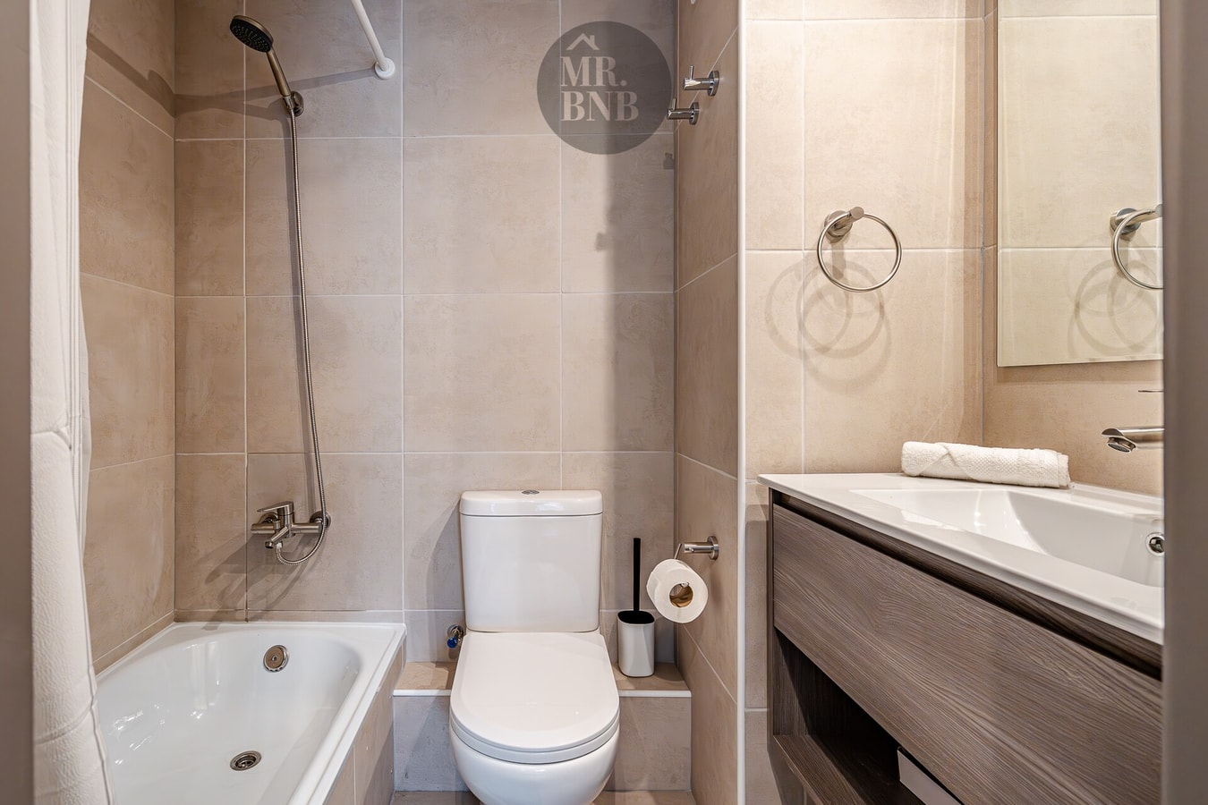 Baño con tina ducha, vanitorio de doble llave y espejo.
