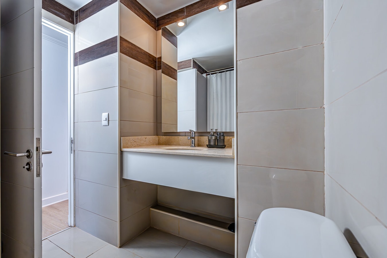 Baño con lavamanos, espejo e inodoro