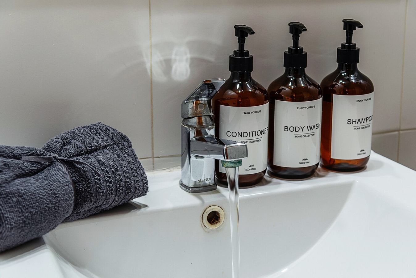 Detalle de lavamanos con toalla y set de amenities de baño.